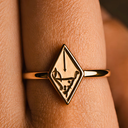 A gold plated arabic calligraphy ring featuring Maktub inspired by the meaning of destiny, shown worn on a finger.