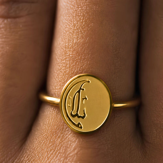 Gold plated Salaam ring featuring Arabic calligraphy by FABLED on a person's finger.