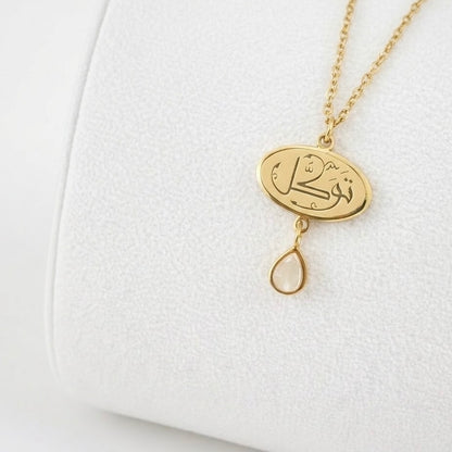 Close-up detail of the FABLED gold plated tawakkul calligraphy necklace