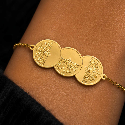 A pattern of rotating plume sprays on a re-imagined traditional layered 3-coin gold bracelet on a person's wrist.